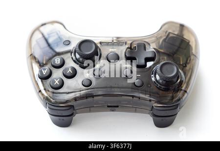 A modern transparent black video game controller is shown isolated against a clean white background Stock Photo