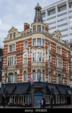 London - 07 22 2022: Great Newport Street corner with ornate brick building and turret. Street corner featuring historic red‑brick building with cream Stock Photo