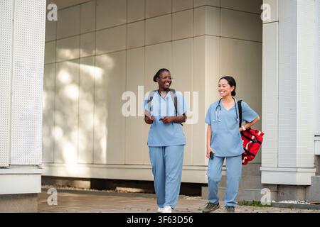Two diverse female nurses smiling discussing professional life Stock Photo