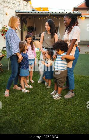 Diverse families happy enjoying backyard party together Stock Photo