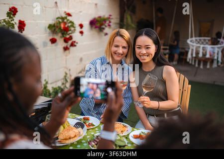 Diverse adult women enjoying outdoor party while taking picture Stock Photo