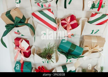 Close-up of part of a Traditional Christmas advent calendar with assorted wrapped gifts hanging on a white wall Stock Photo