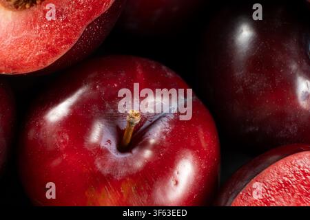 Rich texture of sweet organic plums in dramatic lighting. Stock Photo