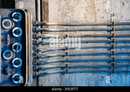 Old surface-mounted electrical wiring with rotary switches in an industrial facility Stock Photo