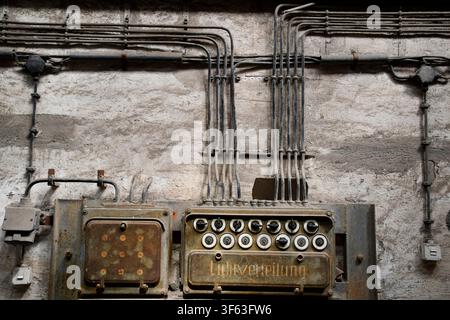 Old surface-mounted electrical wiring with rotary switches in an industrial facility Stock Photo