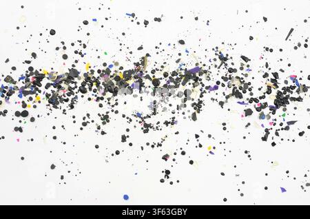 A trail made of tiny pieces of blue, green and black plastic on a light background. A massive threat to the planet. Stock Photo