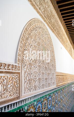 The detailed work of sculpted plaster shows intricate designs on the walls of Madrasa Ben Youssef in Marrakesh. This historic location reflects rich cultural heritage and artistry. Stock Photo
