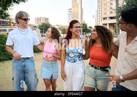 Diverse group of young friends walking and talking in the city Stock Photo