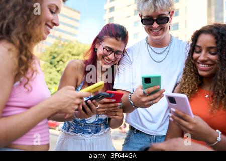 Young people sharing funny content on smartphone in urban setting Stock Photo
