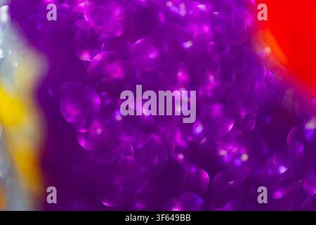 Vibrant bokeh lights in festive celebration setting, featuring circular glowing orbs with purple, pink, and magenta hues, soft blurred background with Stock Photo