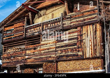 A barn filled with hay and firewood in South Tyrol Stock Photo