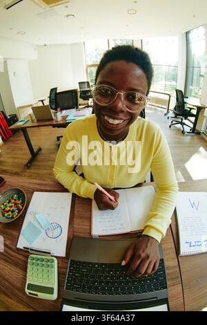 Portrait of Smiling Black Woman Working on Laptop in Office Stock Photo