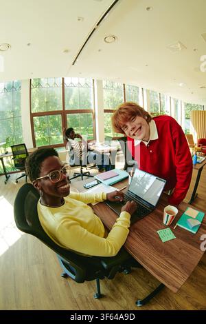 Portrait of Diverse Colleagues Smiling and Working on Laptop in Office Stock Photo
