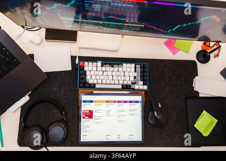 Digital Tablet Screen Display Agile Kanban Board Interface Workspace Top View. A modern desk setup featuring a tablet with task management cards inclu Stock Photo