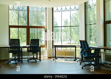 Empty Modern Coworking Space with Large Windows and Office Chairs Stock Photo