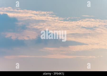 Soft pastel sunset clouds over a serene sky, gentle pink and blue hues blending in the atmosphere Stock Photo