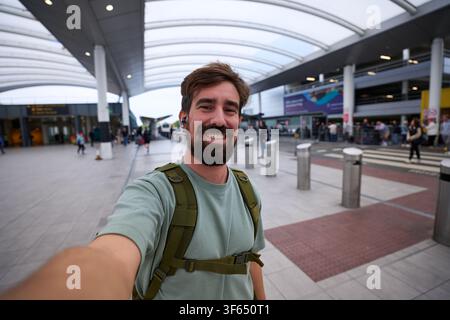 Man smiling taking selfie at airport terminal. Stock Photo
