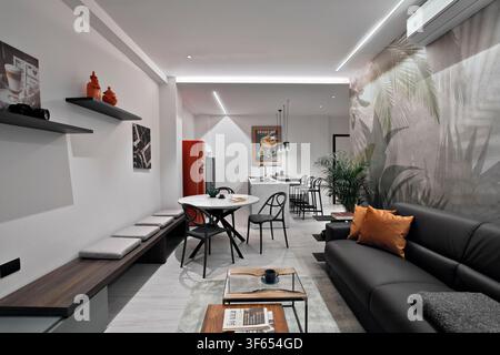 Contemporary apartment in Turin, Italy, converted from office to residential use, showing the living room, dining area and open-plan kitchen Stock Photo