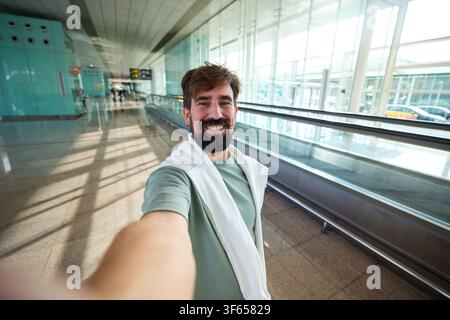 Happy man taking selfie travelling through airport Stock Photo