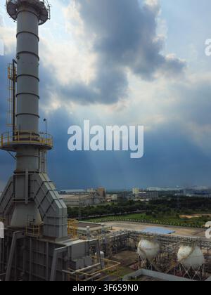 Industrial plant and refinery facilities under dramatic sky with crepuscular rays. Stock Photo