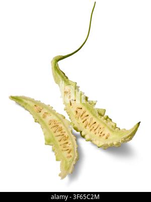 sliced bitter melon isolated white background, green bumpy skin and exposed seeds inside fresh vegetable, cut in half Stock Photo
