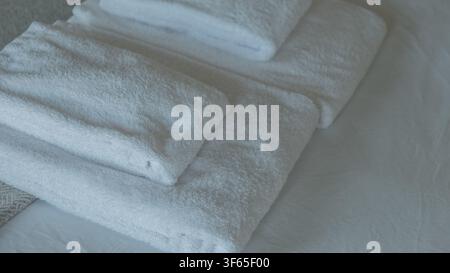 Folded White Cotton Terry Towels Arranged on a Bed in Soft Natural Light — Hotel Hospitality, Clean Linen and Spa Comfort Concept Stock Photo