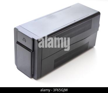 A black uninterruptible power supply unit stands upright against a clean white background Stock Photo