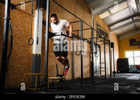 Athletic man doing dips at crossfit gym Stock Photo