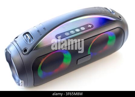 A modern black wireless portable bluetooth speaker featuring colorful LED lighting is displayed on a white background Stock Photo