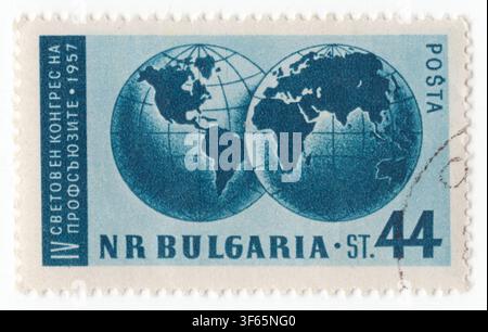 BULGARIA — 1957 October 4: 44 stotinki Prussian blue postage stamp depicts two overlapping globes displaying the Eastern and Western Hemispheres with grid lines. This artwork commemorates the 4th World Trade Union Congress organized by the World Federation of Trade Unions. The image symbolizes global labor solidarity, international worker unity, and worldwide cooperation. Released during the political administration of Todor Zhivkov, the design highlights state support for internationalism, socialist labor rights, and working-class organization in the People's Republic of Bulgaria Stock Photo