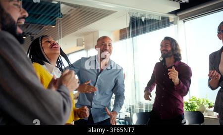 Diverse team celebrating in modern office Stock Photo