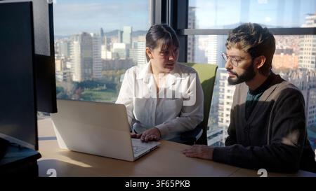 Business colleagues having serious discussion beside laptop in modern office Stock Photo