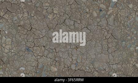 Overhead detail view of cracked dry clay soil and embedded stones showing drought texture. Stock Photo