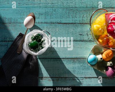 Decorated Easter eggs arranged on a rustic turquoise wooden table with vintage spoon and spring styling Stock Photo