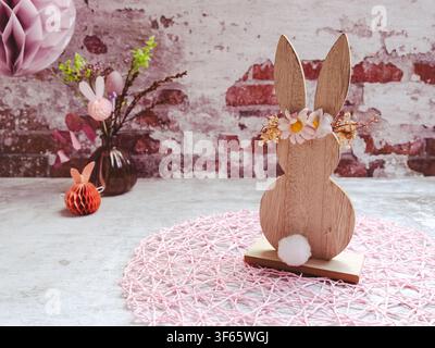 Decorative Easter bunny displayed beside a ceramic vase and festive Easter decorations on a rustic background Stock Photo