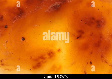 Amber Panel Revealing Uniform Golden Translucent Glow With Tiny Dark Specks And Subtle Cloudy Zones In Macro Studio Composition. Stock Photo