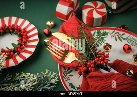 Elegant Christmas Table Setting with Gold Cutlery and Festive Decorations Stock Photo