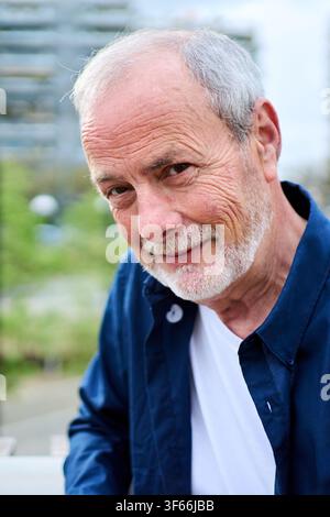 Portrait of handsome Caucasian mature man posing looking confident at camera outdoors. Stock Photo