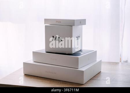 Stack of Apple product boxes on wooden table. Apple product unboxing, new apple devices boxes, unpacking apple tech purchase. Warsaw, Poland, 20 July Stock Photo