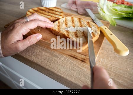 Preparing a grilled ham and cheese sandwich with fresh ingredients at home Stock Photo