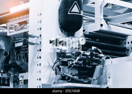 Large modern metalworking machine with many parts, tubes and hoses with compressed air cylinder and pressure gauge. tech industrial technology backgro Stock Photo