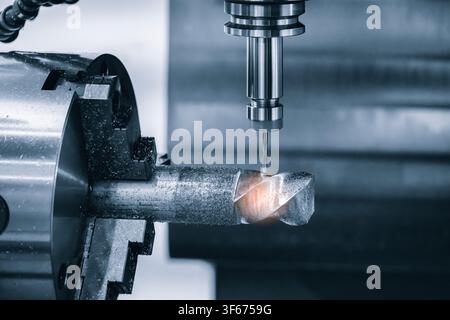 Close-up of precision metalworking machine. Cylindrical metal workpiece rotates inside  machine. Tool bit hovers above workpiece for machining. tech i Stock Photo