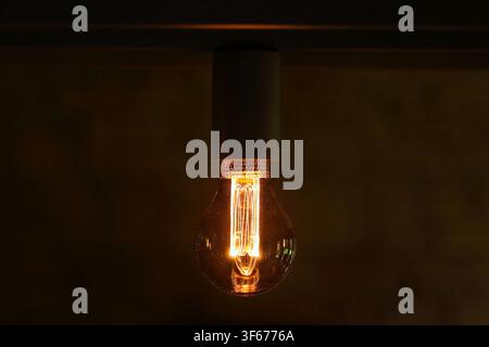 Light bulb switched on close up on dark background Stock Photo