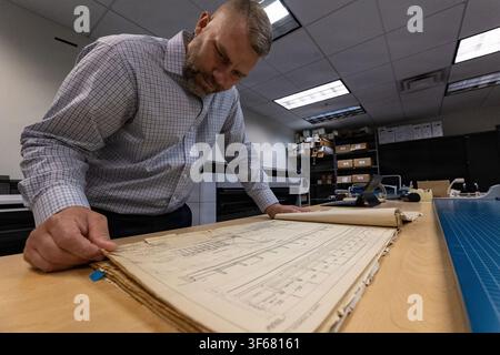 Chris Miller, a regional technical specialist with the Great Lakes and Ohio River Division, reviews paper CAD mapping for Montgomery Locks and Dam on the Ohio River near Pittsburgh, Pennsylvania, utilizing Computer-Aided Design (CAD) and Building Information Modeling (BIM) technologies. Stock Photo