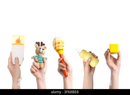 Women holding sunscreen, toy deer and other baby stuff on white background, set Stock Photo