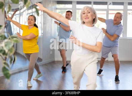 Woman participating in Zumba class for seniors in fitness studio Stock Photo