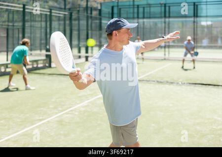 Adult men playing padel against two men Stock Photo