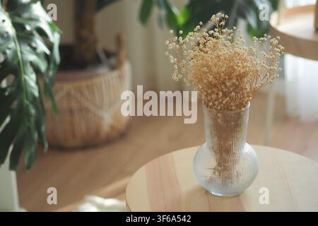 Dried flowers in a glass vase on a wooden table Stock Photo