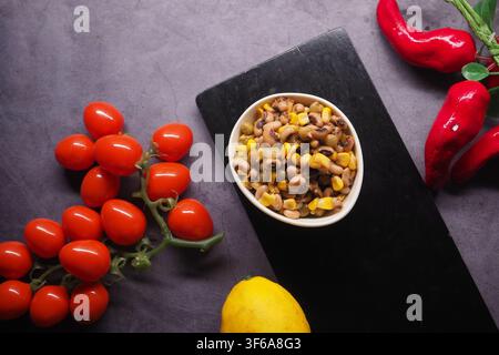 Fresh vegetables and beans on a black cutting board Stock Photo