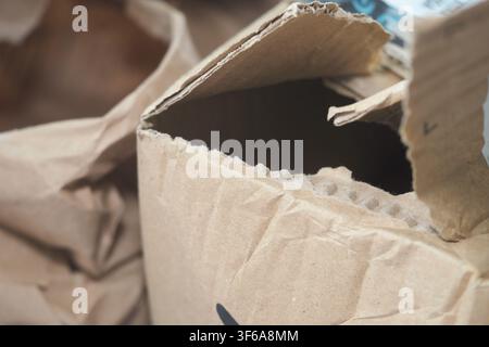 Cardboard box is open with torn edges sitting on the ground Stock Photo